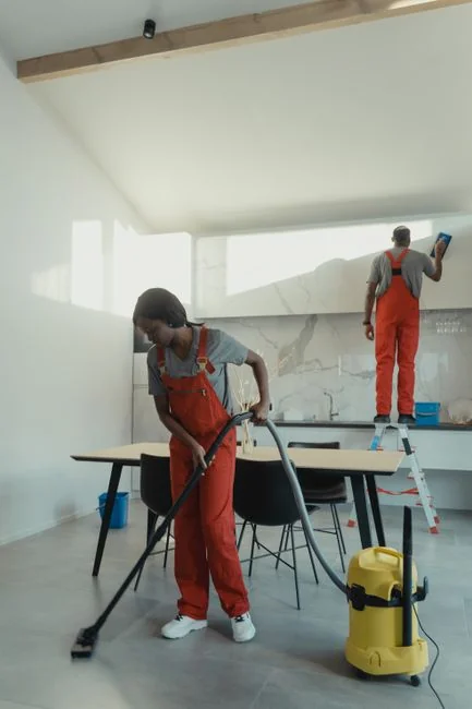 A person sanitizes a work area through fumigation while wearing complete protective equipment for safety.